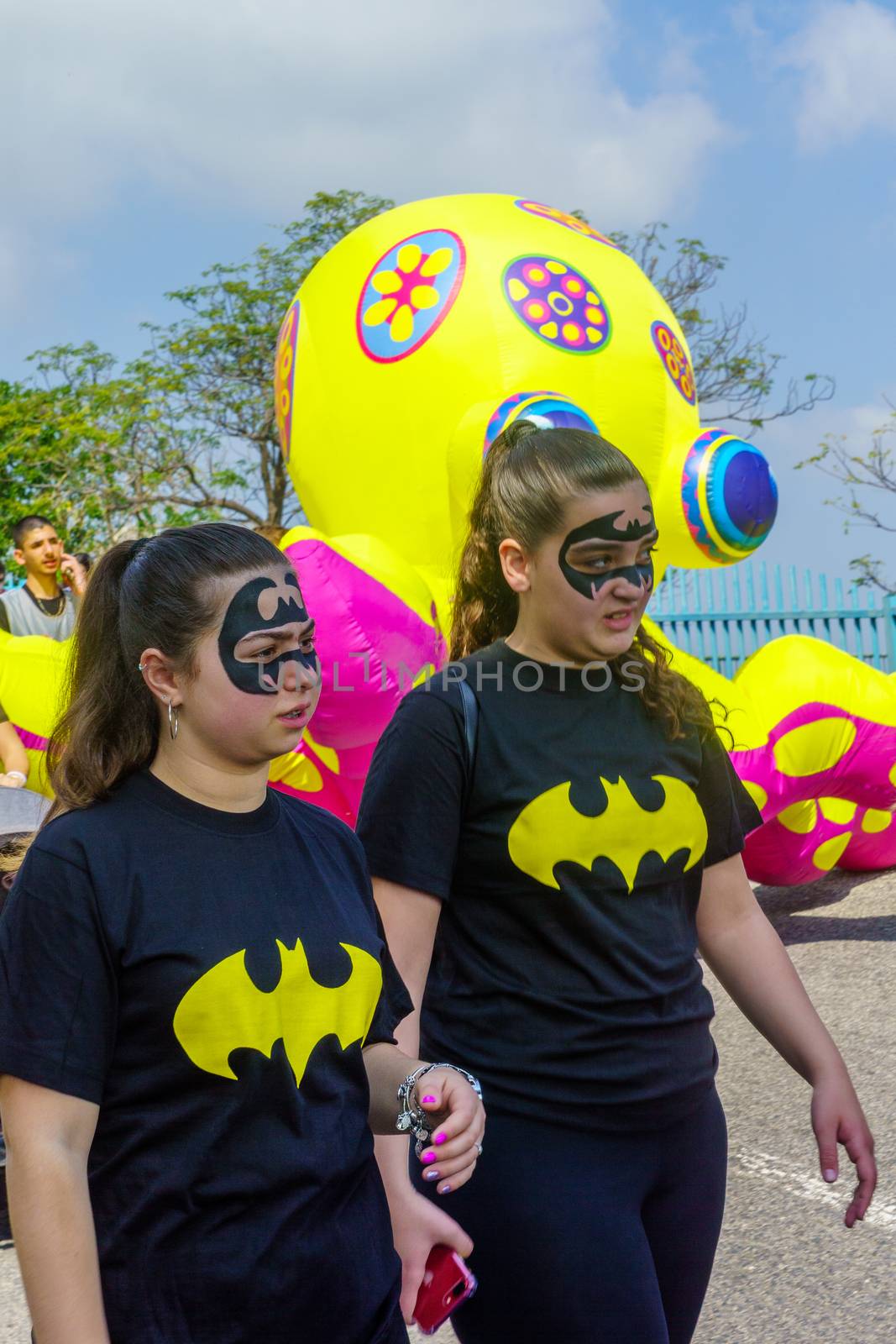 Nesher, Israel - March 22, 2019: People, some in costumes, celebrate the Jewish holyday of Purim in the Adloyada parade, in Nesher, Israel