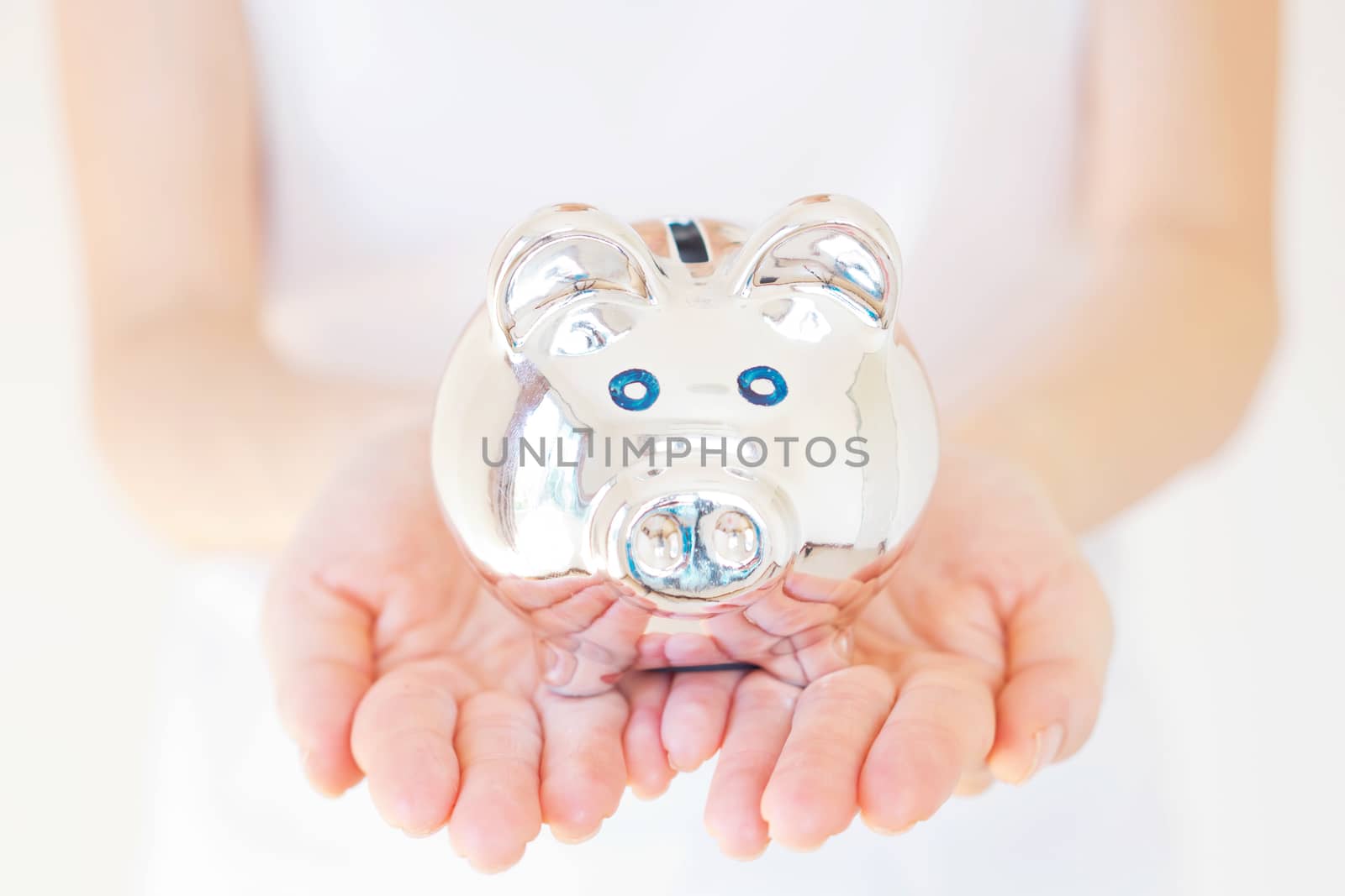 woman holding white piggy bank over body background.