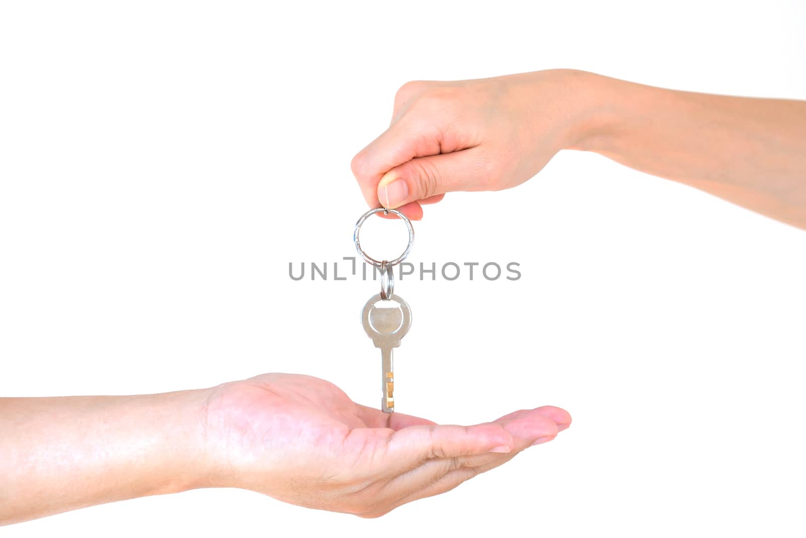 Male hand holding a key and handing it over to another person isolated