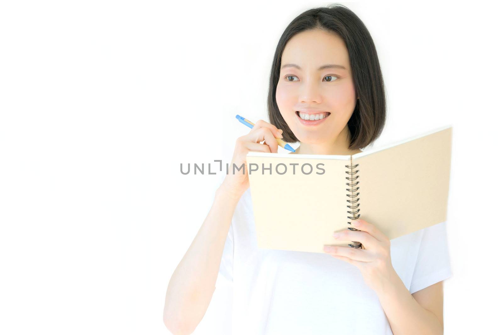 A pensive college girl with a pen and a textbook, isolated on white