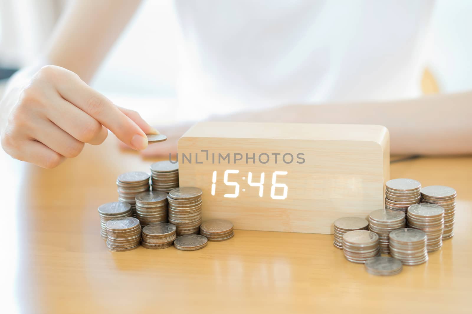 Close up of female hand stacking gold coins isolated on white background