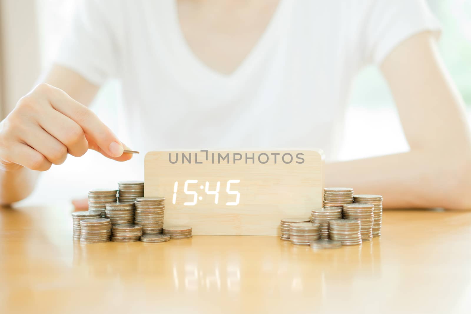 Close up of female hand stacking gold coins isolated on white background
