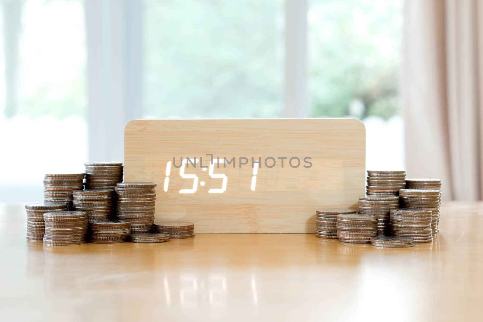 Digital time is money concept. Pound coins in foreground blurred, 