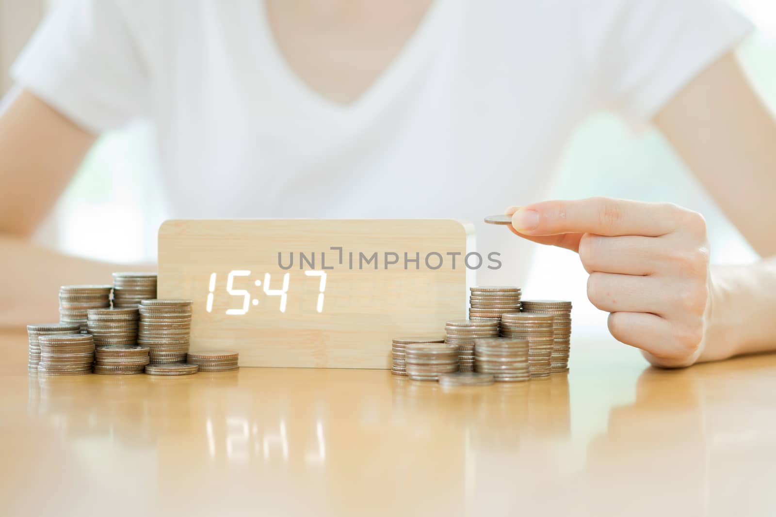 Close up of female hand stacking gold coins isolated on white background