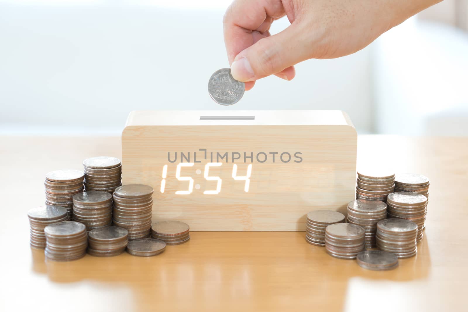 Close up of female hand stacking gold coins isolated on white background