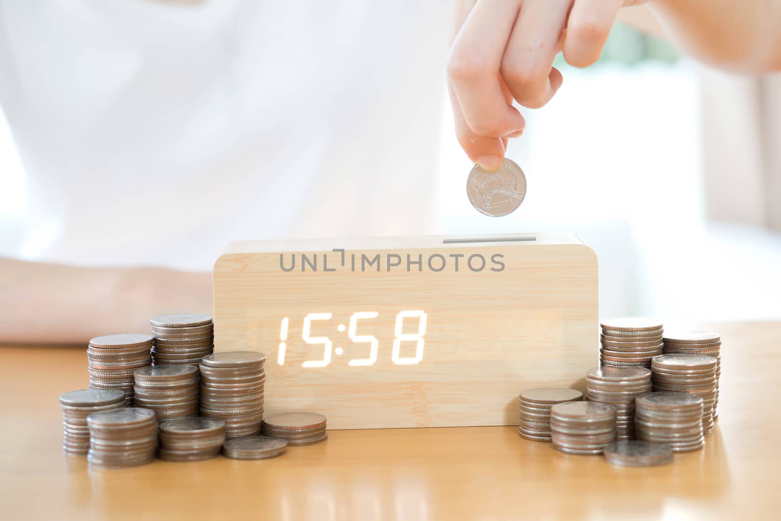 Close up of female hand stacking gold coins isolated on white background