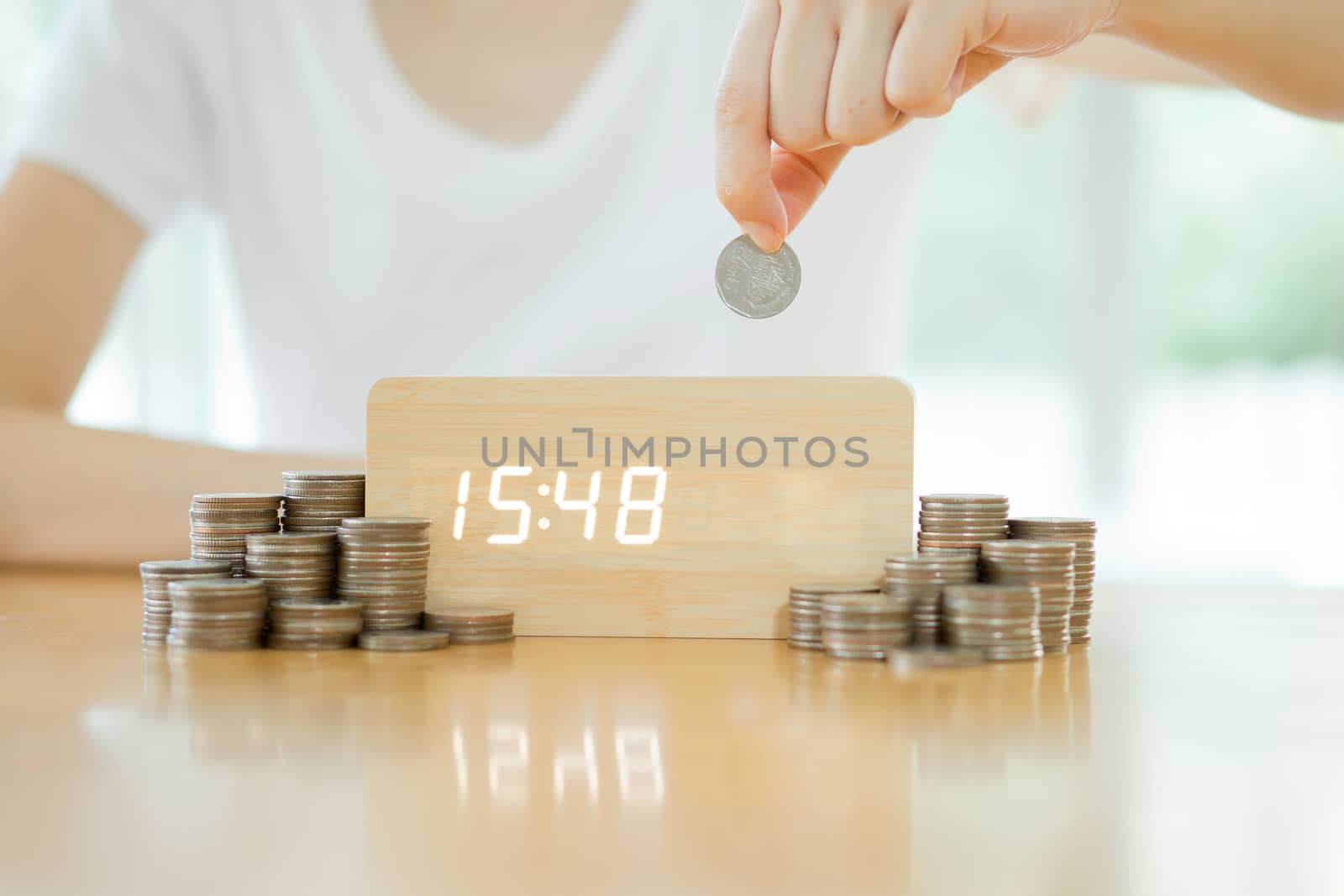 Close up of female hand stacking gold coins isolated on white background