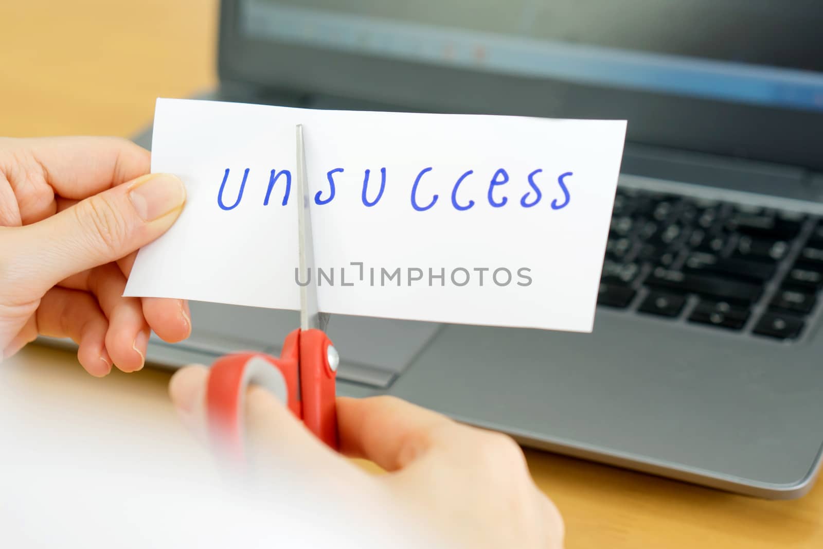 holds card with text unsccess on computer