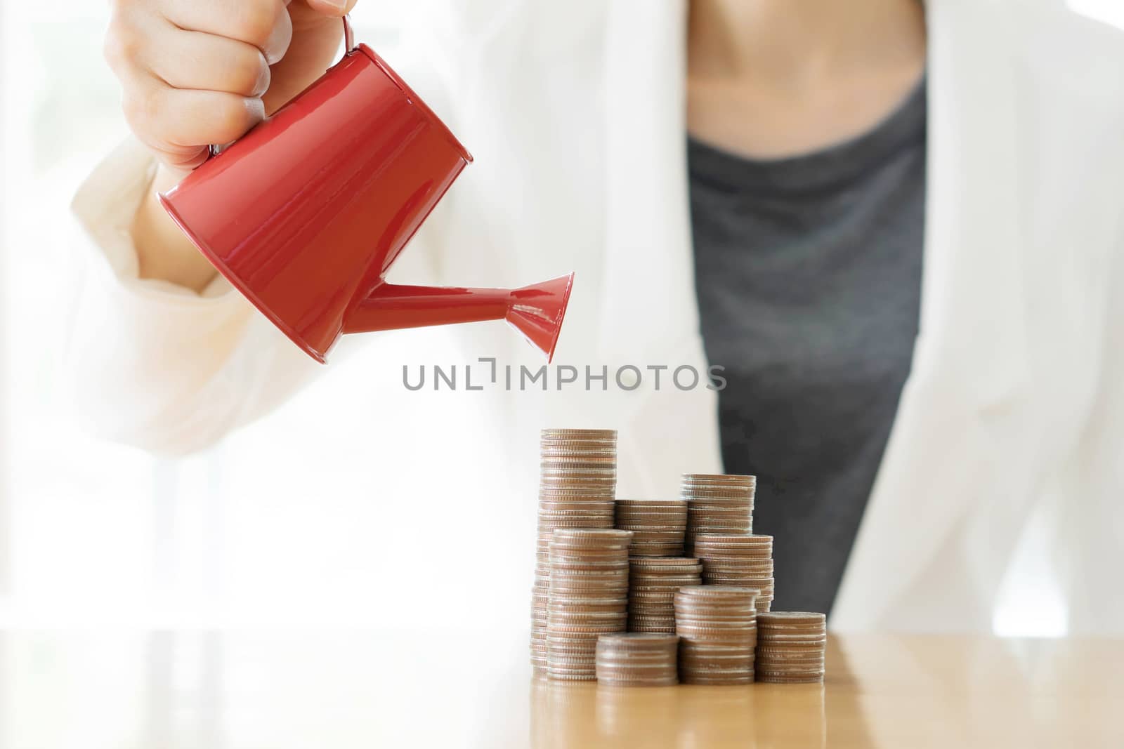hand business woman and red watering can with money