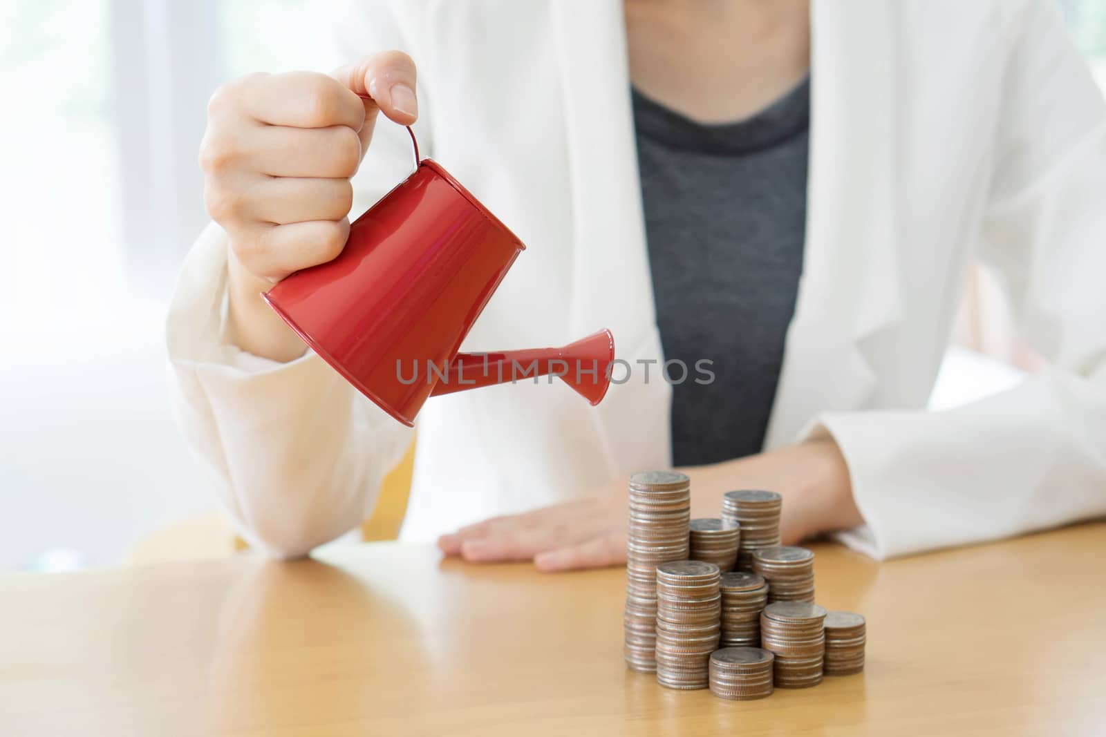 hand business woman and red watering can with money