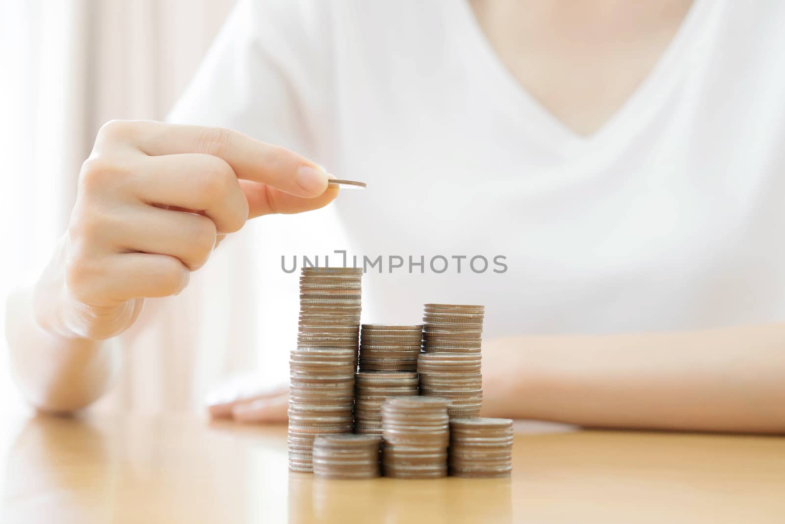Hand put coins to stack of coins on white background