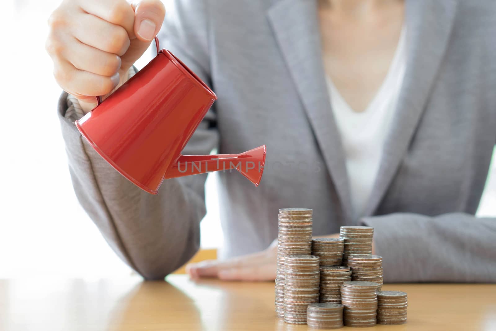 hand business woman and red watering can with money
