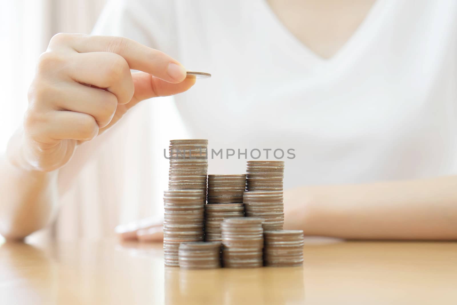 Hand put coins to stack of coins on white background