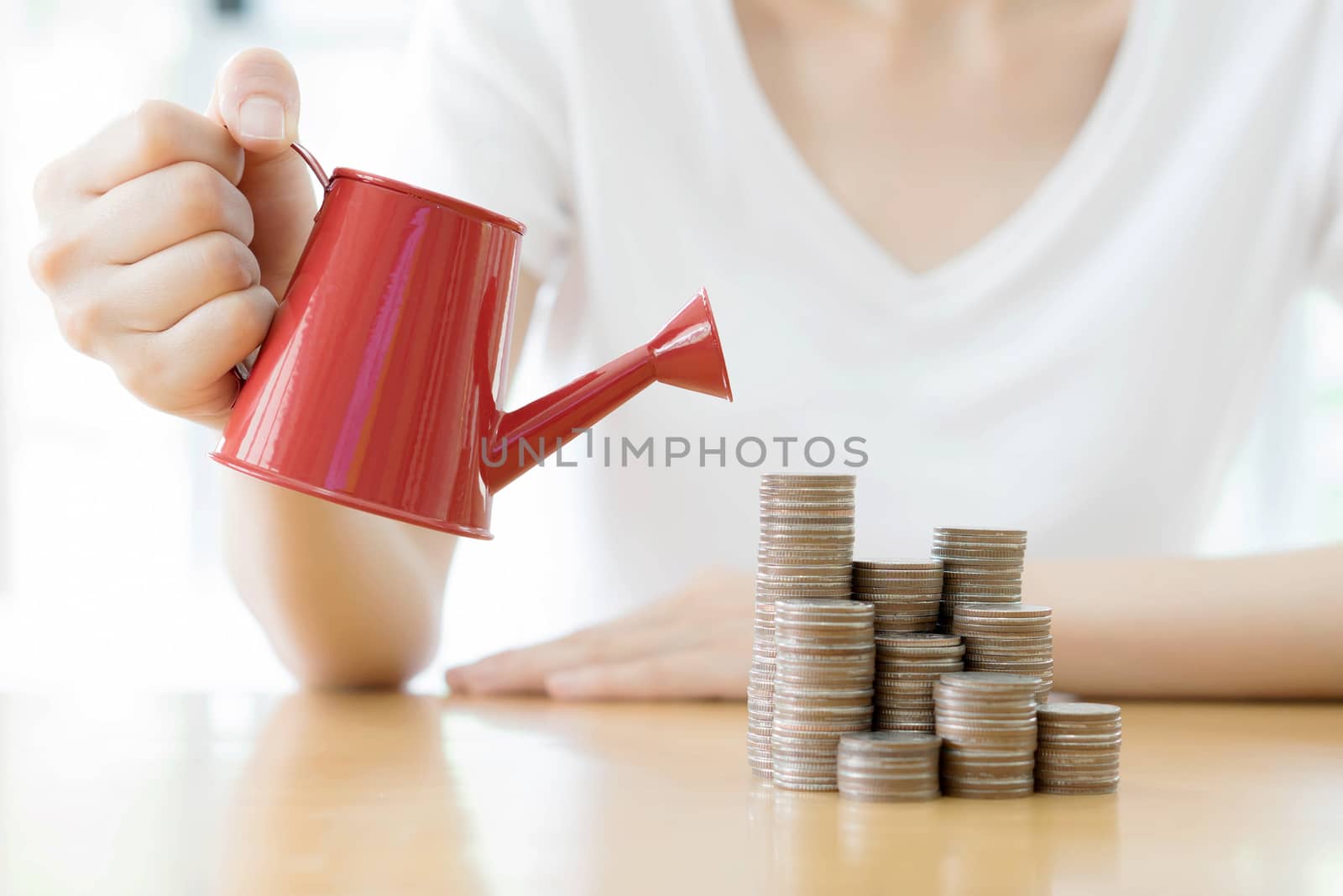 hand business woman and red watering can with money