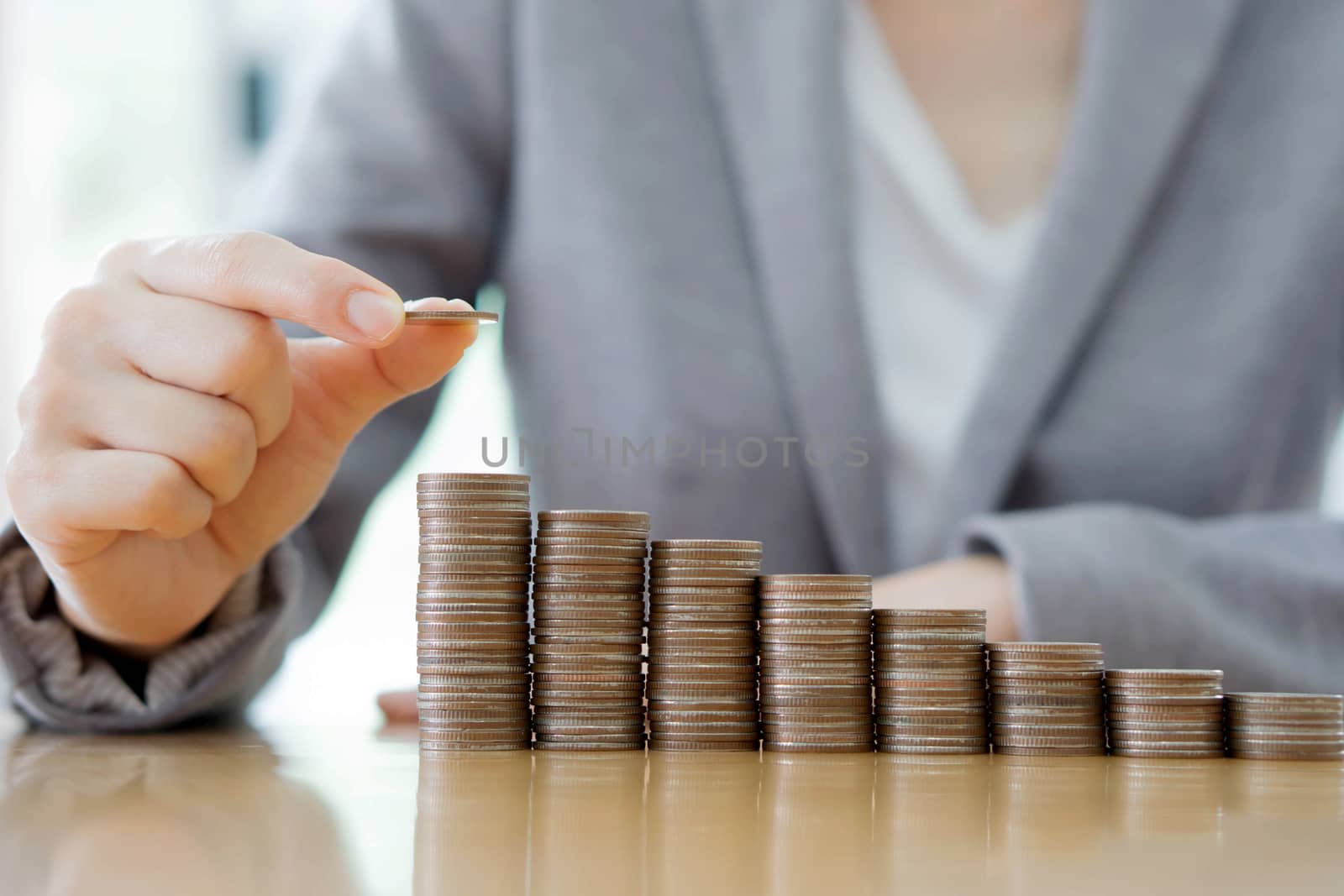 Close-up Of A Businesswoman Making Stack Of Coins