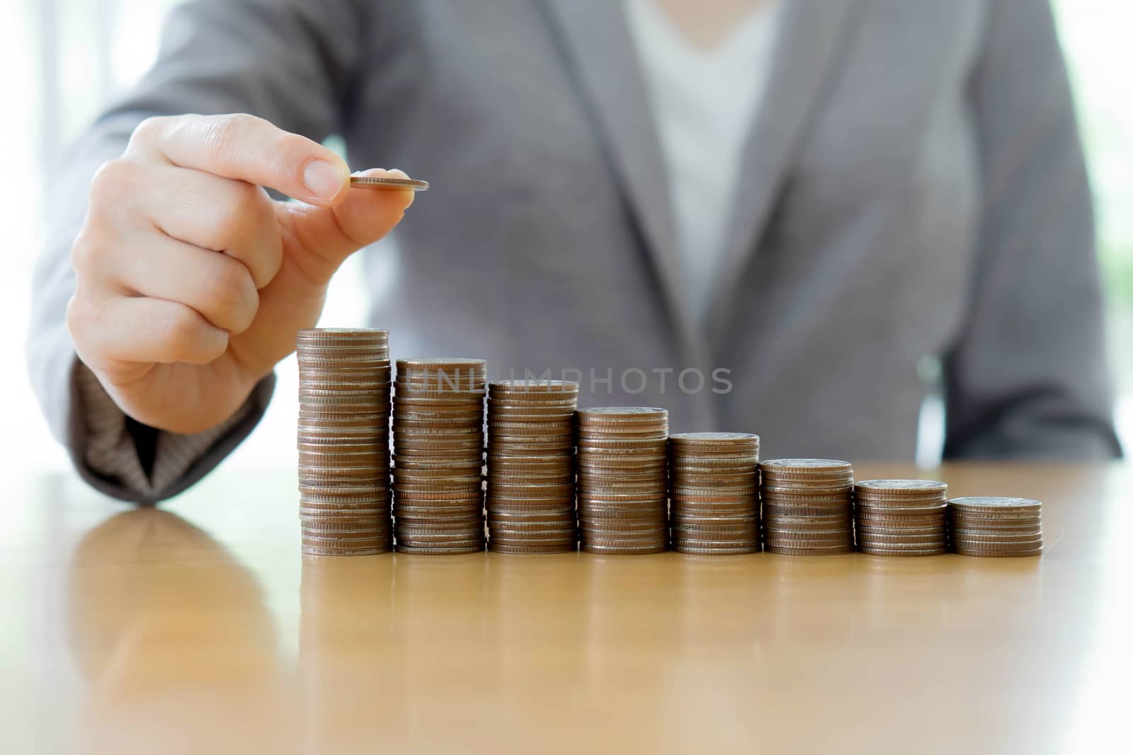 Close-up Of A Businesswoman Making Stack Of Coins