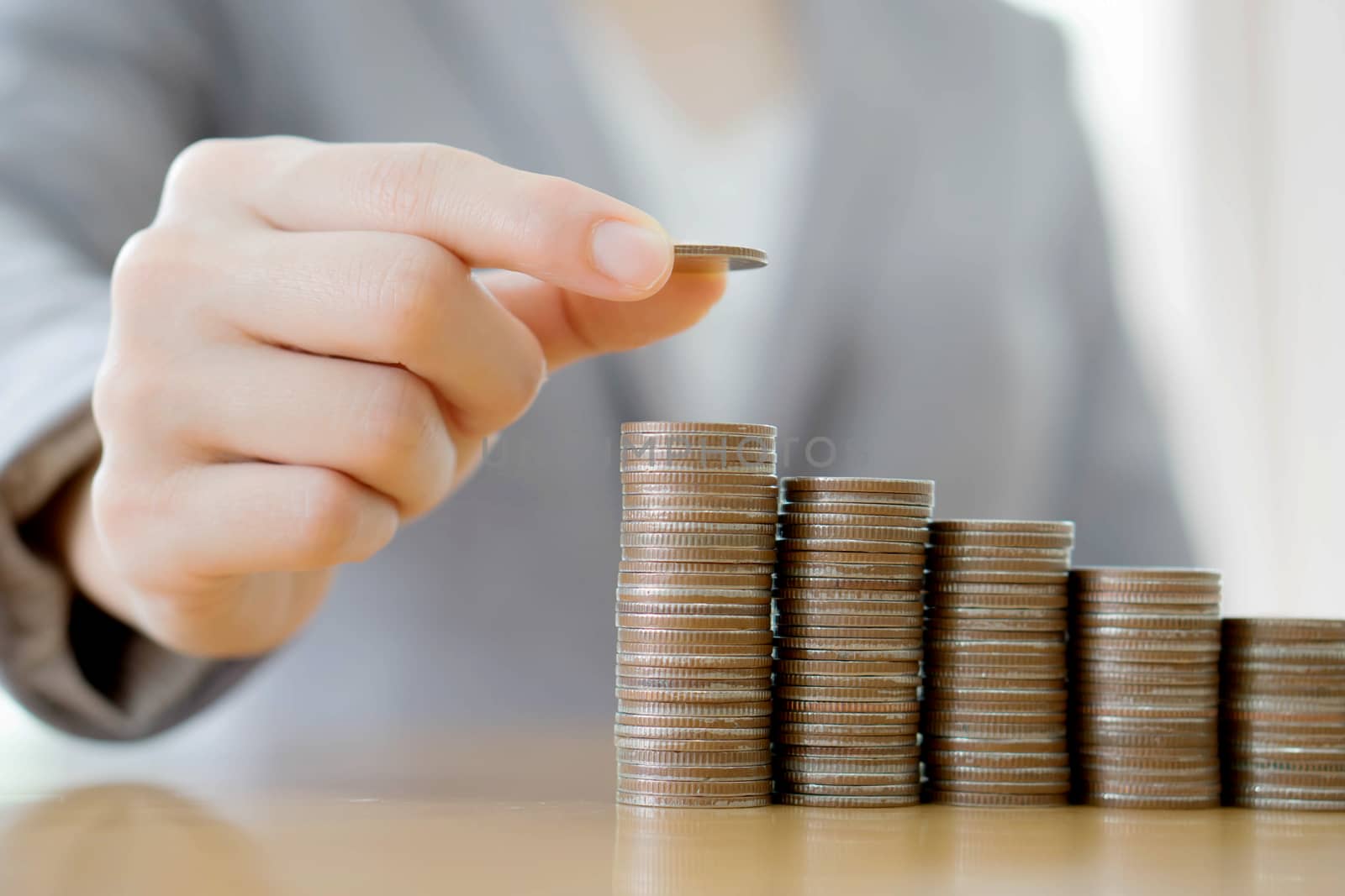 Close-up Of A Businesswoman Making Stack Of Coins
