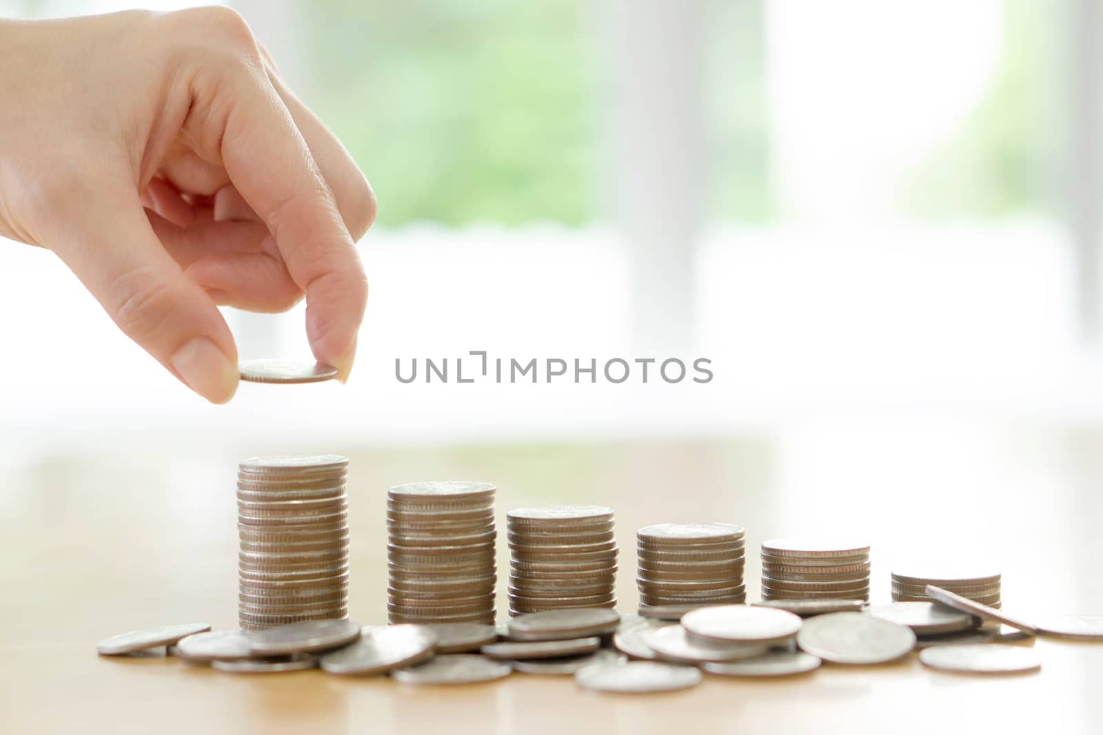 woman put coins to stack of coins