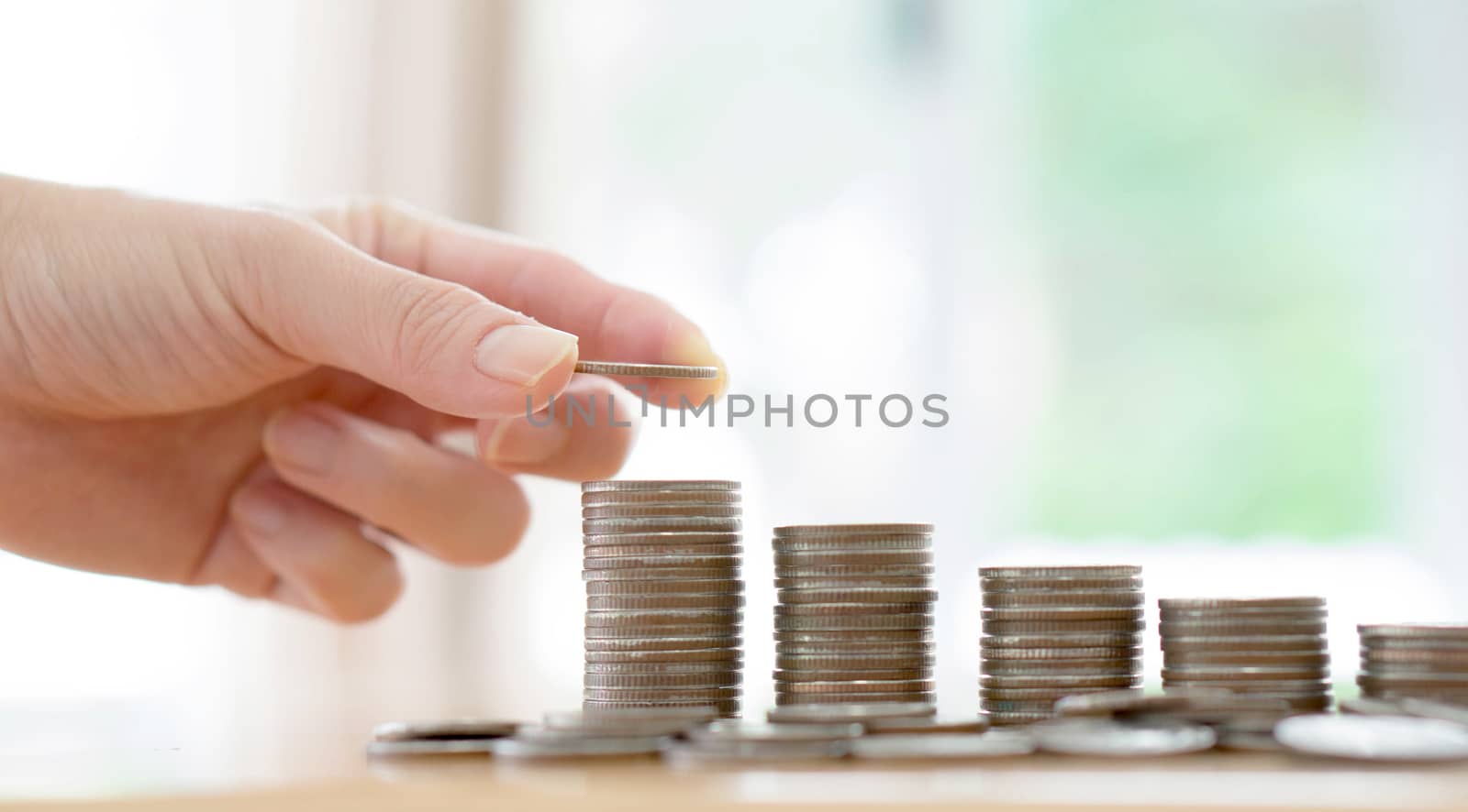 woman put coins to stack of coins
