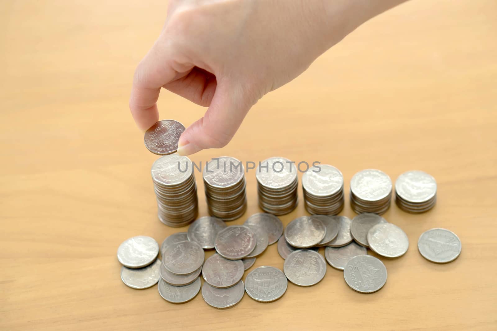 woman put coins to stack of coins