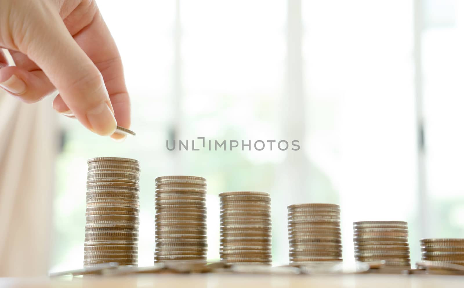 woman put coins to stack of coins