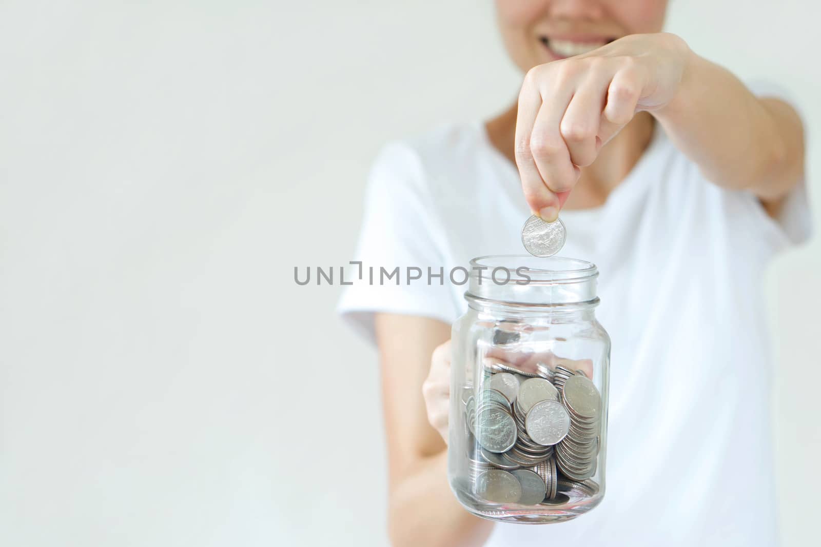 Woman hands with coins in glass jar