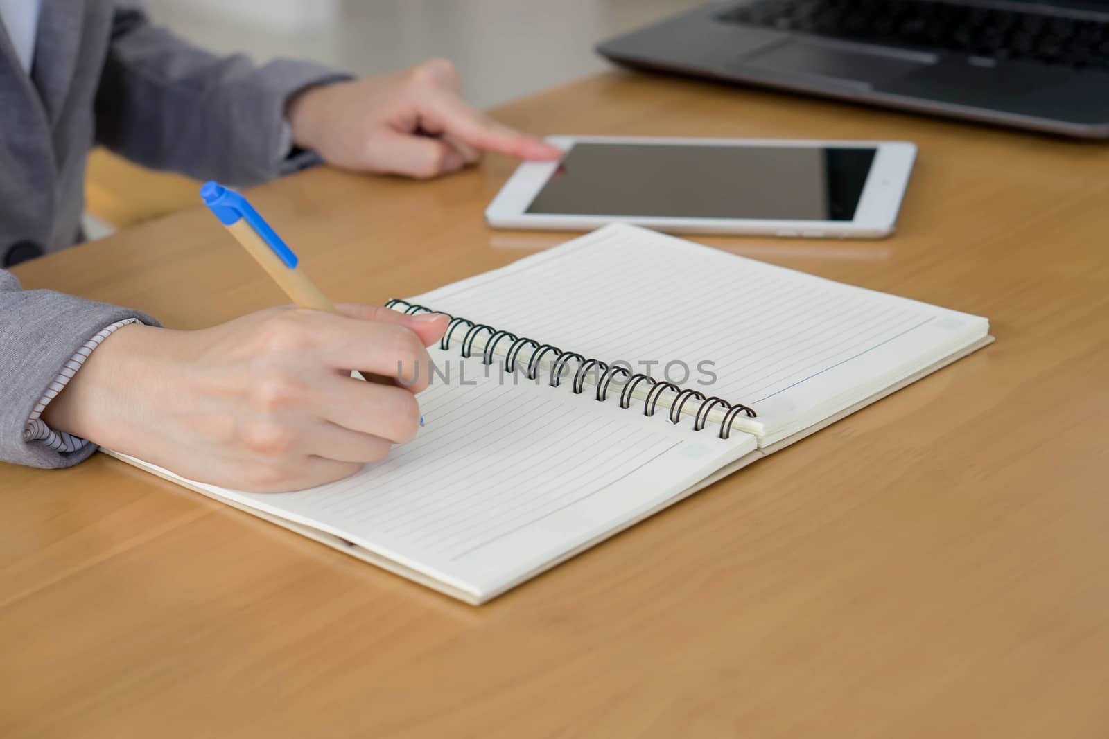 Woman hands with tablet PC and notepad at office