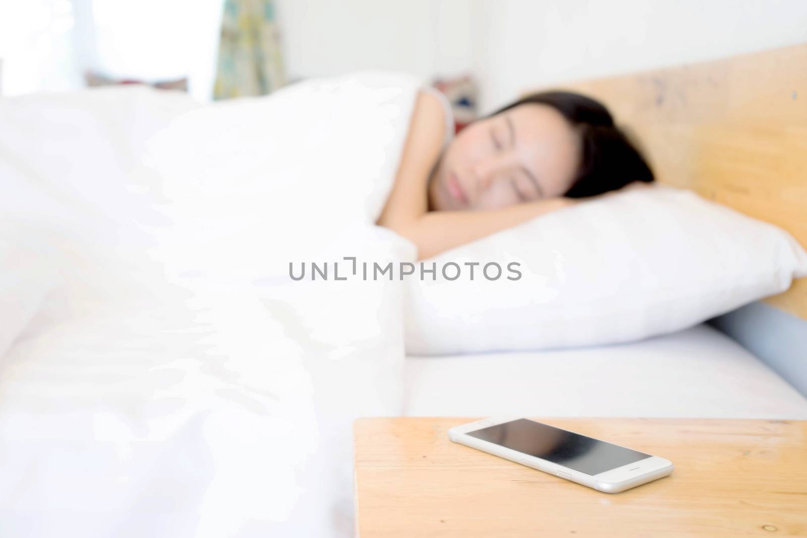 Sleeping Woman Being Woken By Mobile Phone In Bedroom by ekachailo