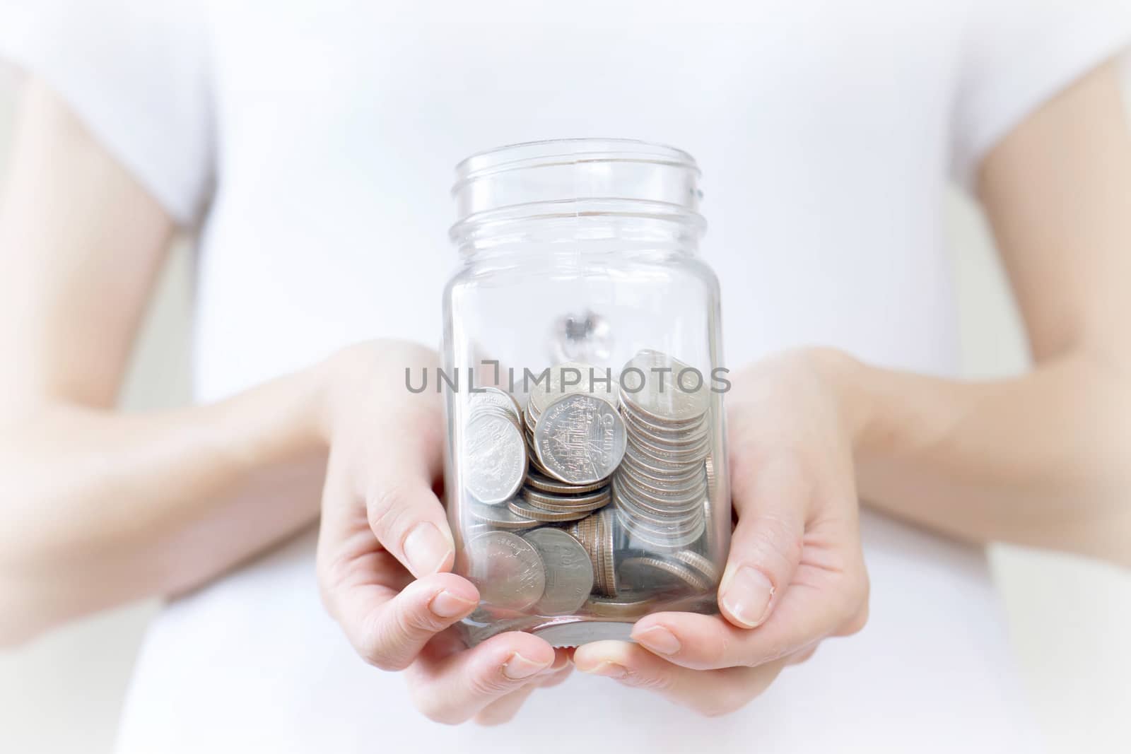 Woman holding money jar with coins close up