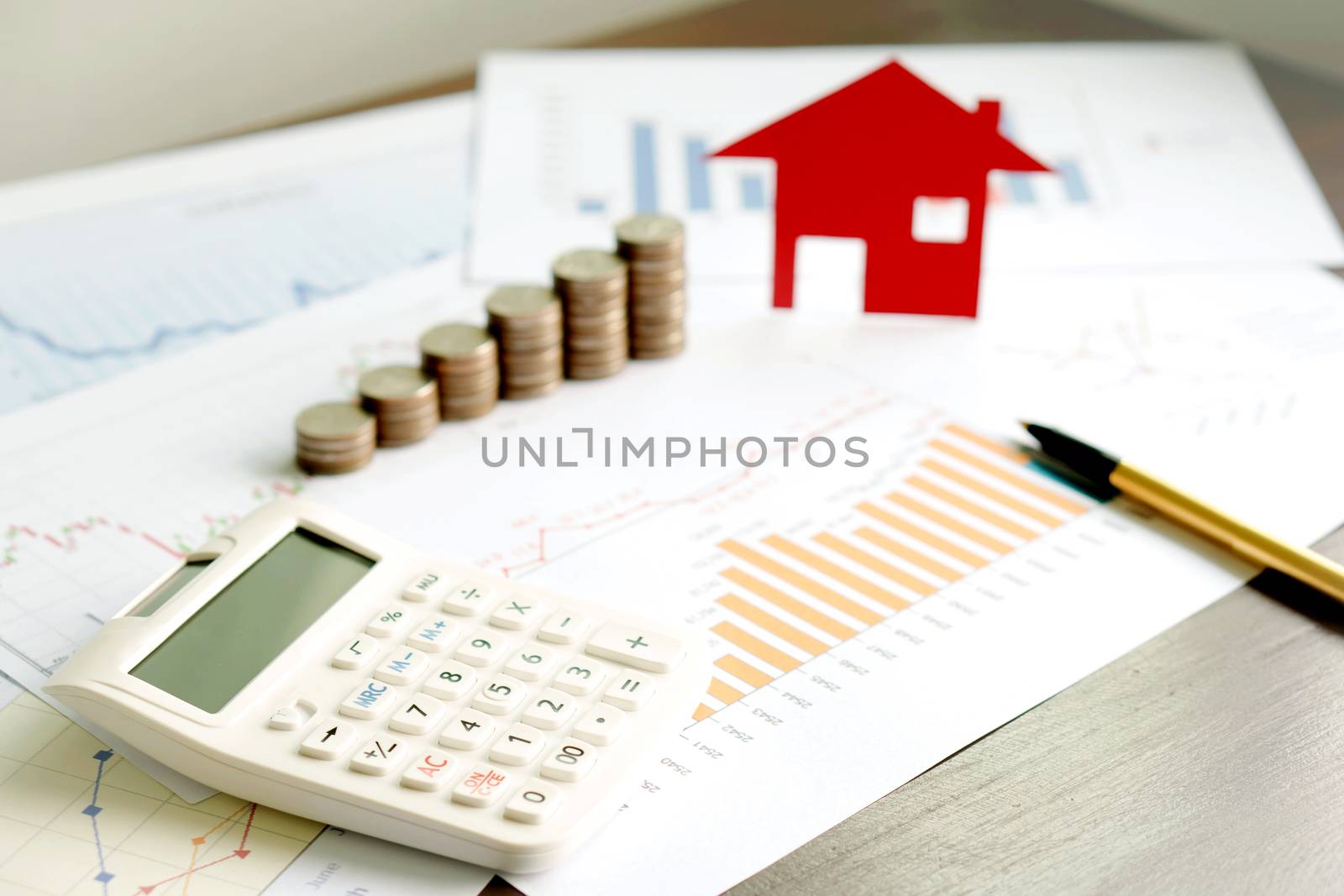  With House Model And Stack Of Coins On Desk
