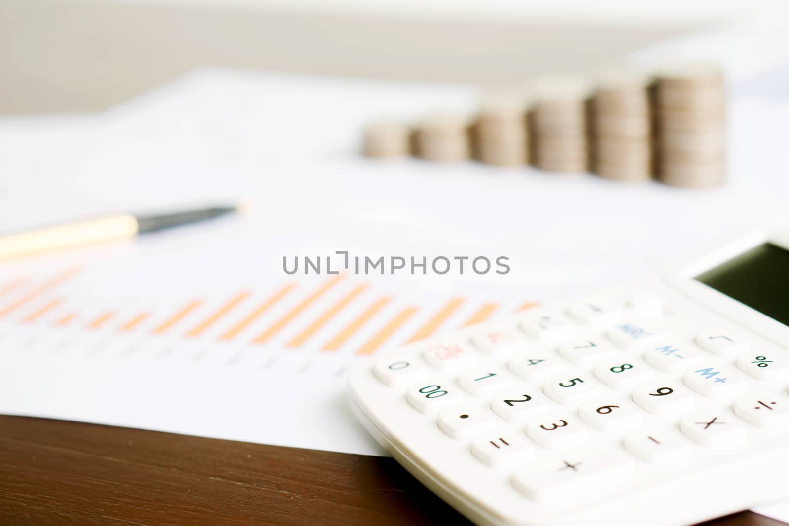 Selective focus calculator, pencil , coin on chart document.