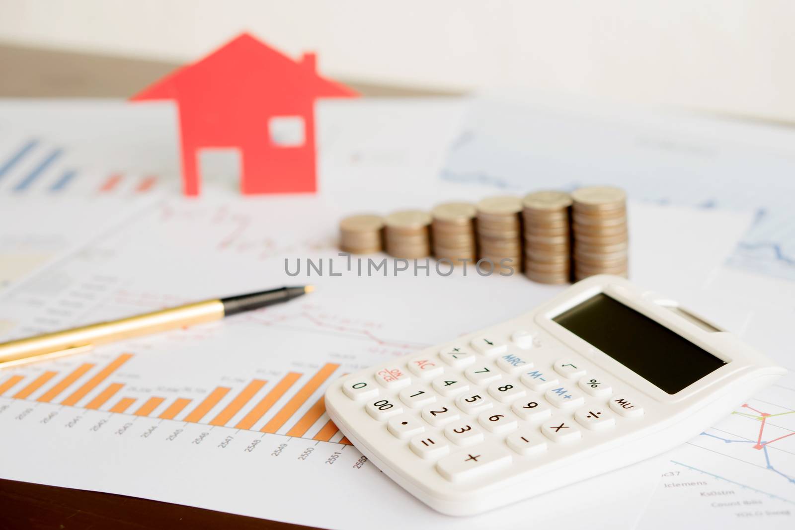  With House Model And Stack Of Coins On Desk