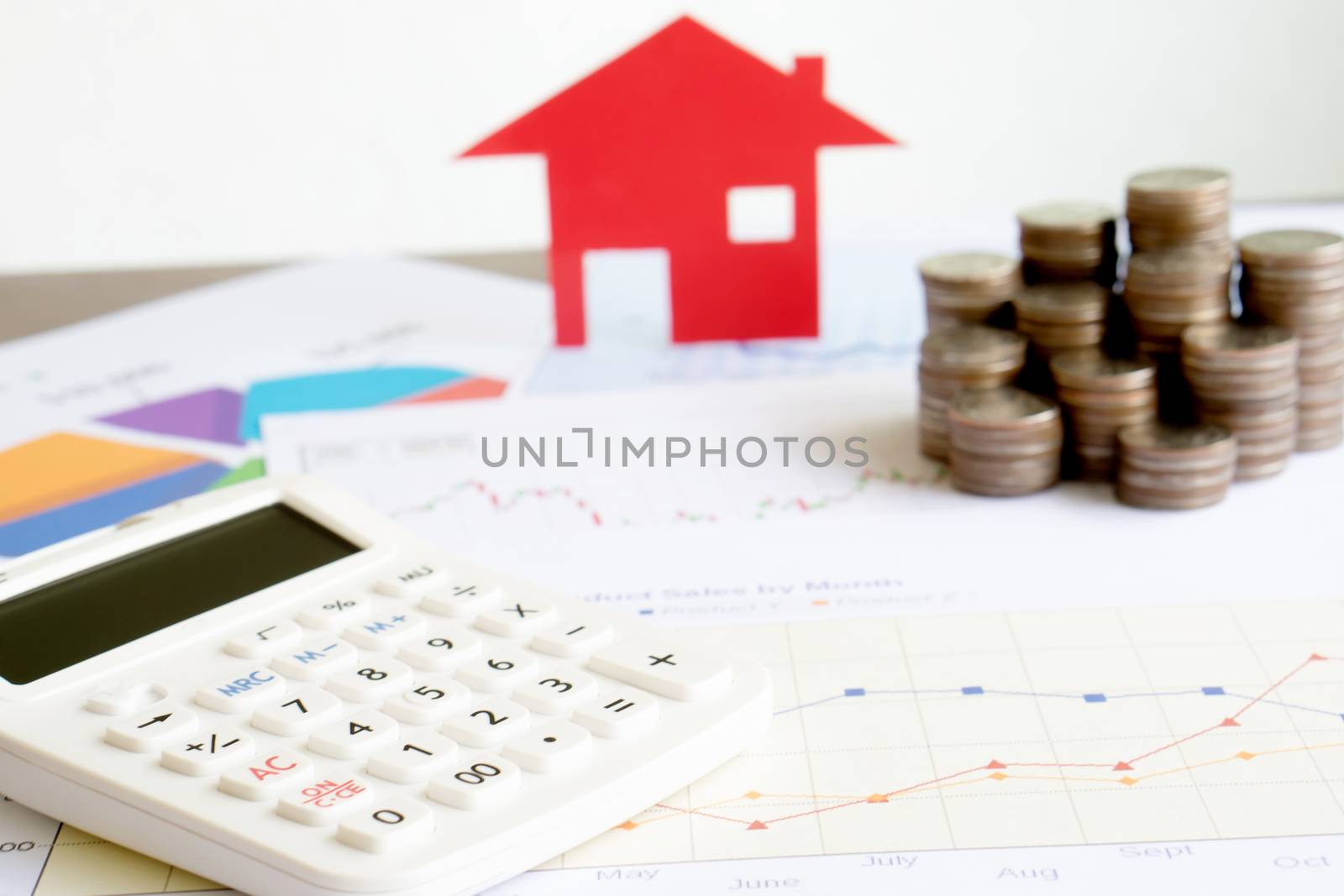  With House Model And Stack Of Coins On Desk