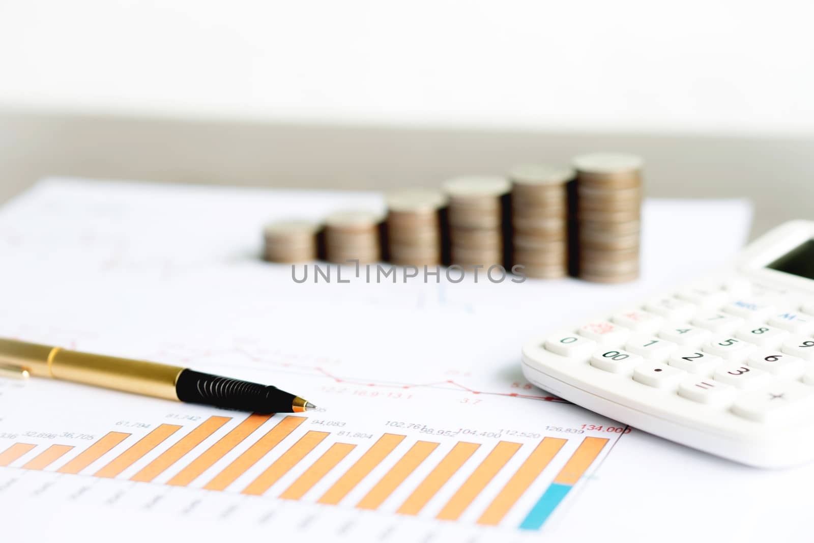 graph with calculator, pen and coins