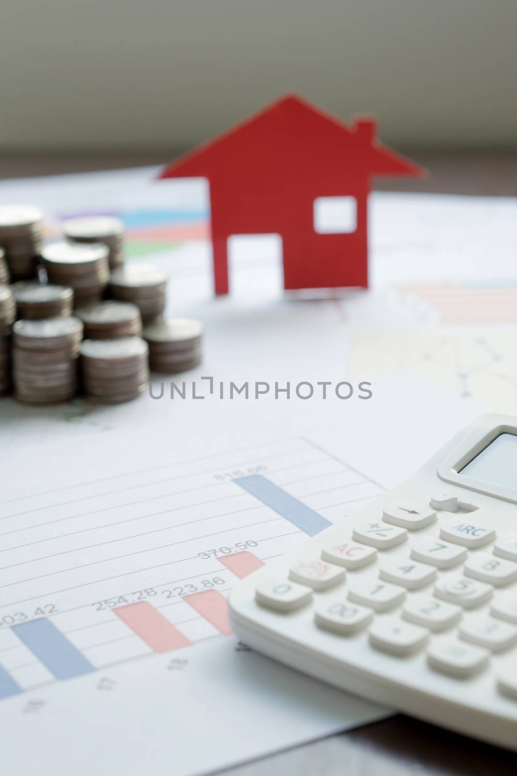  With House Model And Stack Of Coins On Desk by ekachailo