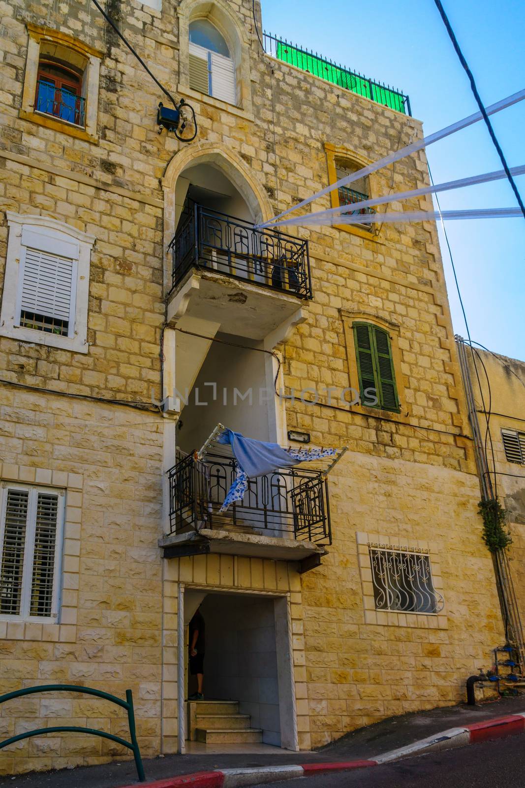 HAIFA, ISRAEL - OCTOBER 27, 2017: Historical houses in mixed Arab and International (Bauhaus) style, with locals and visitors, in Haifa, Israel