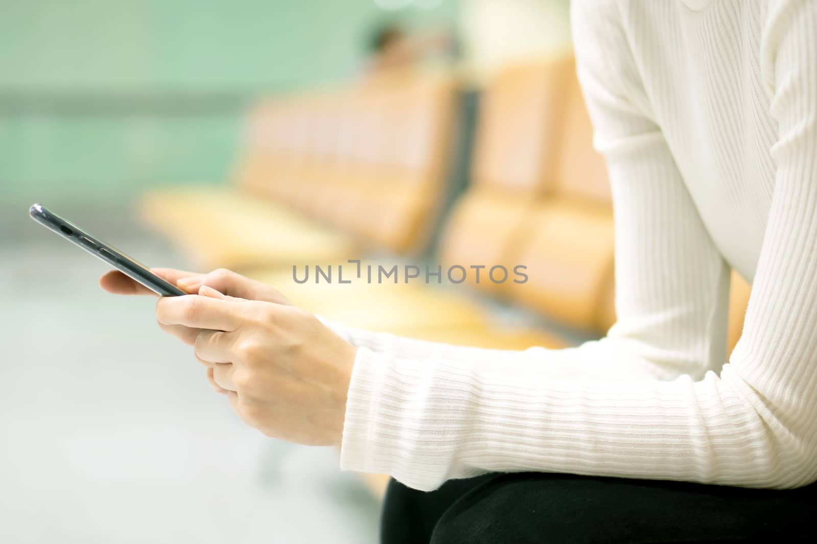 Woman at airport texting on a smartphone 