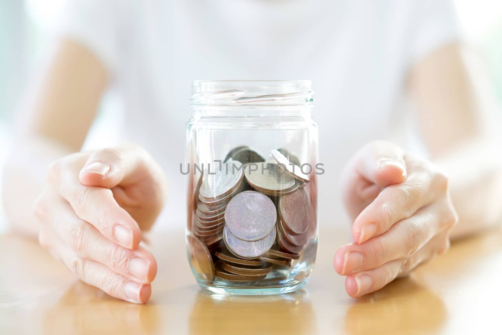 Woman holding money jar with coins close up