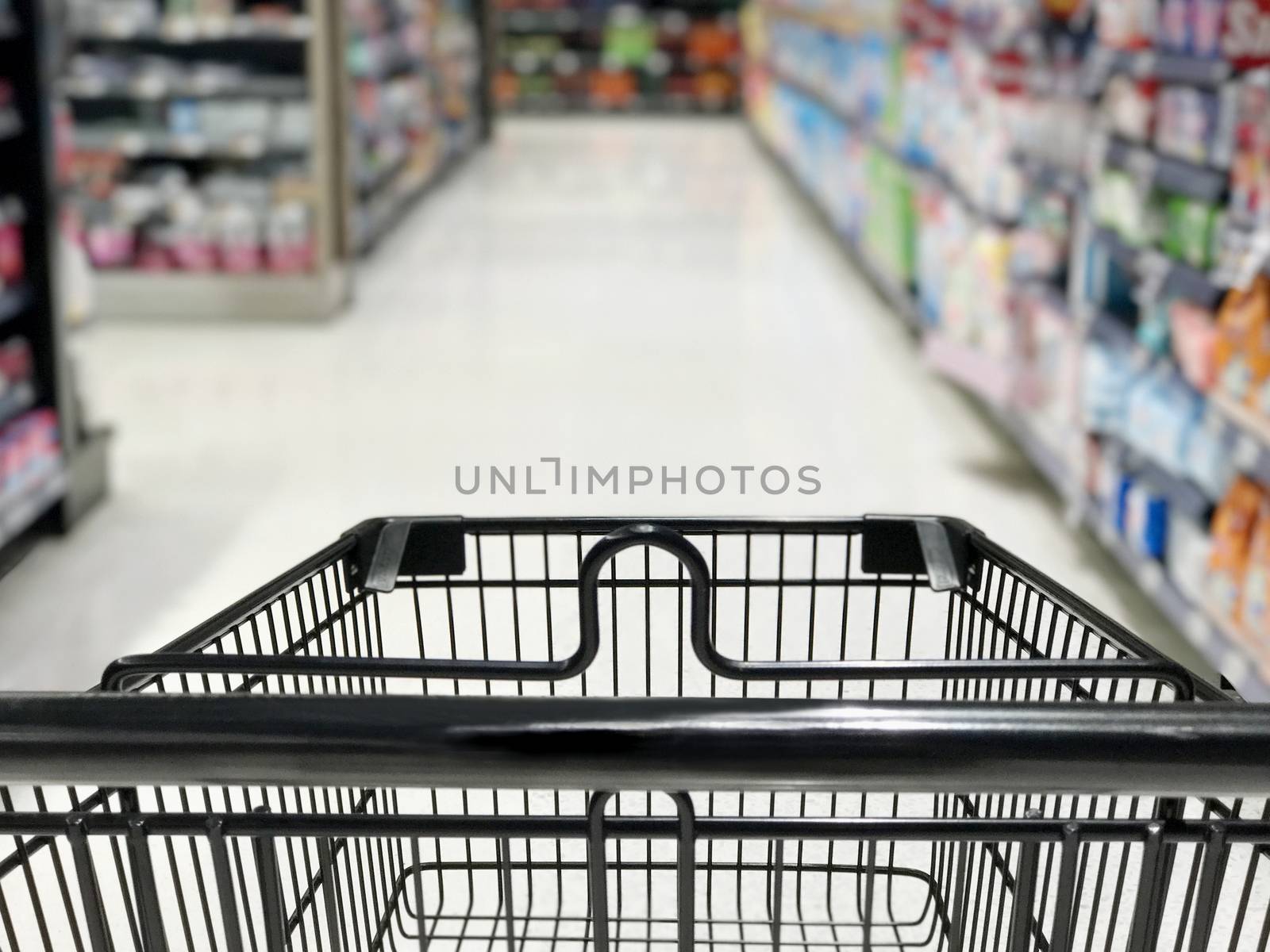 Shopping cart with wine bottles shelves in supermarket by ekachailo