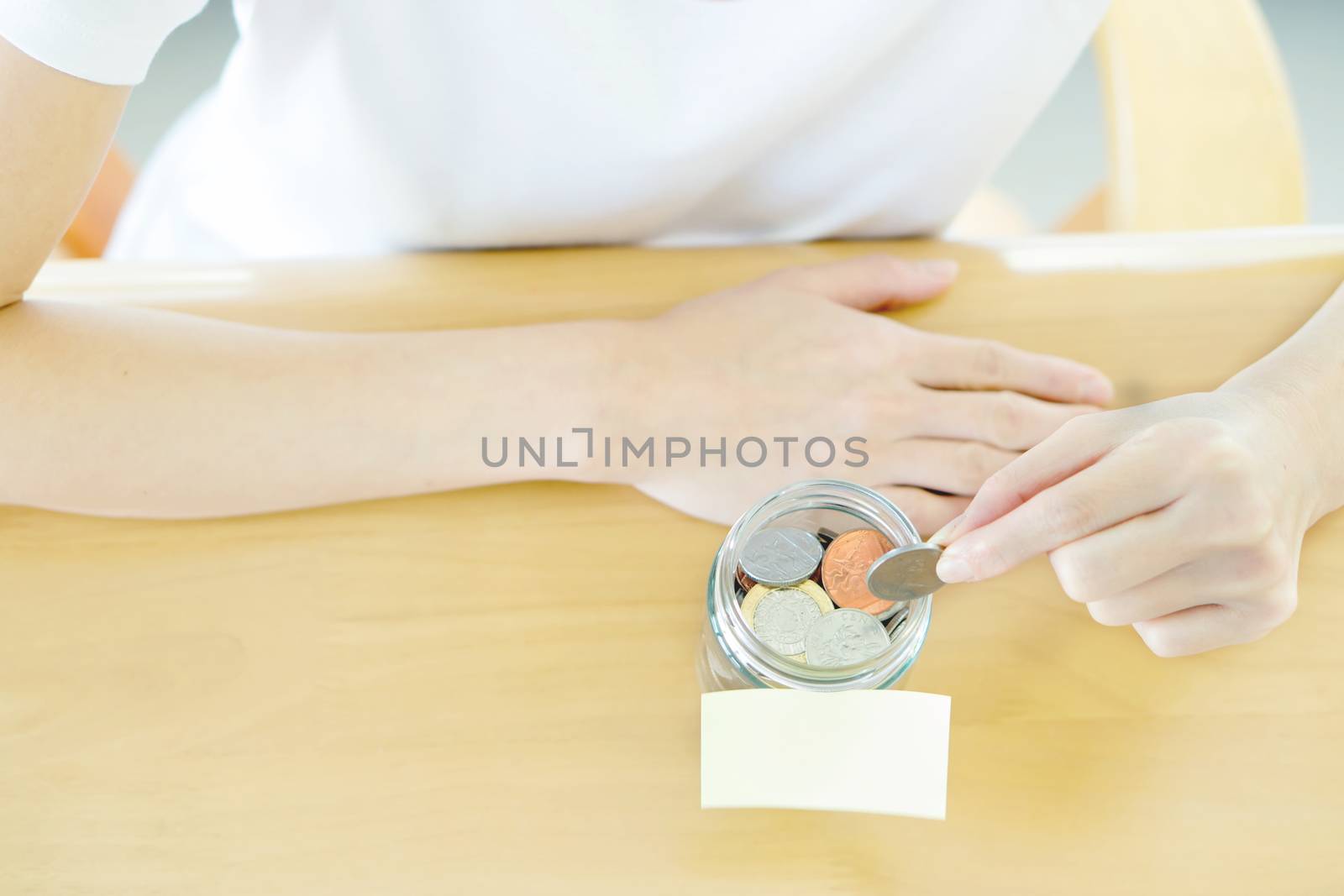 Woman hands with coins in glass jar, top view by ekachailo