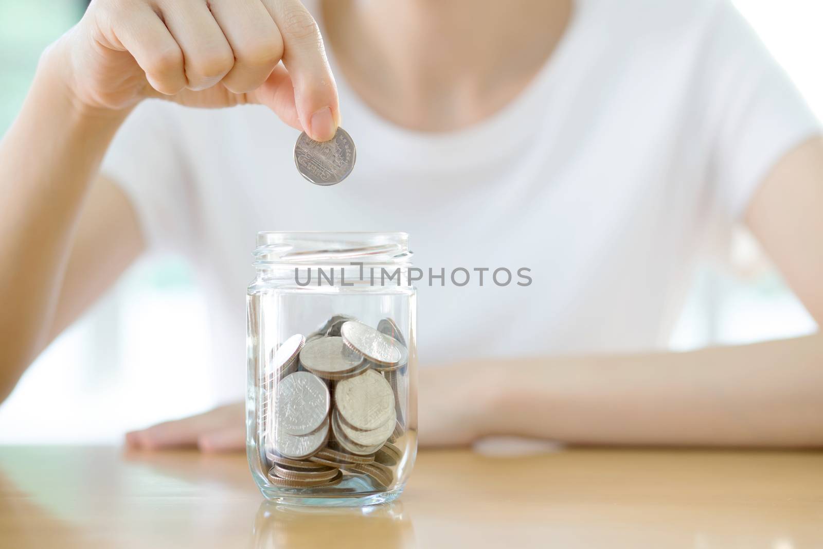 Woman hands with coins in glass jar, close up