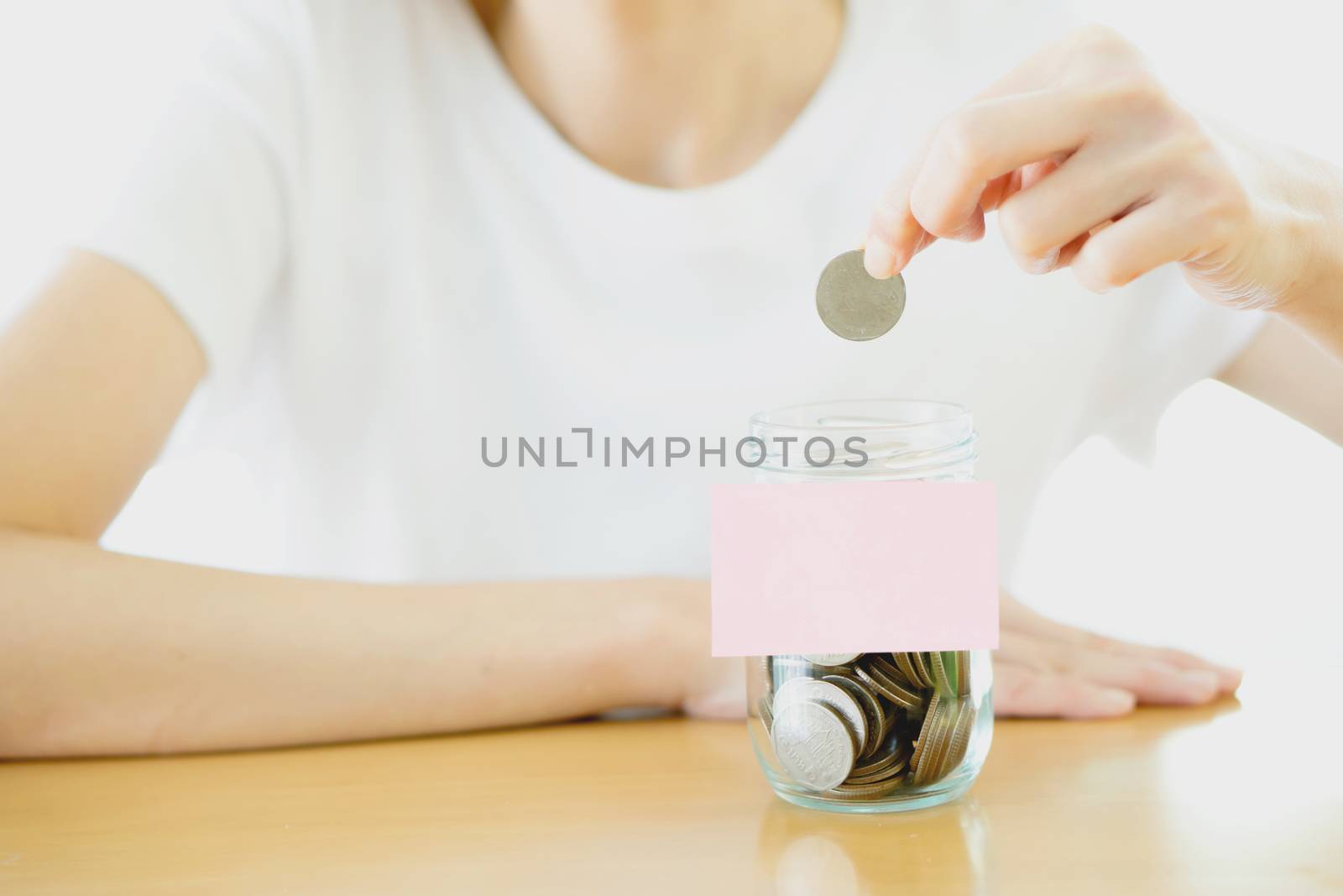 Woman hands with coins in glass jar, close up by ekachailo