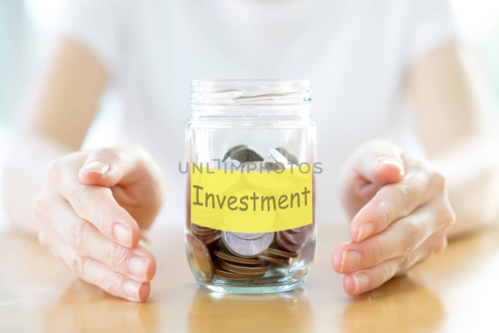 Woman holding money jar with coins close up by ekachailo