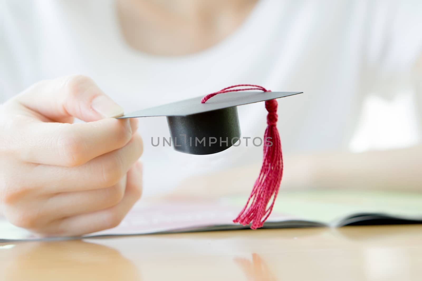 woman hand  hold graduation cap, conception by ekachailo