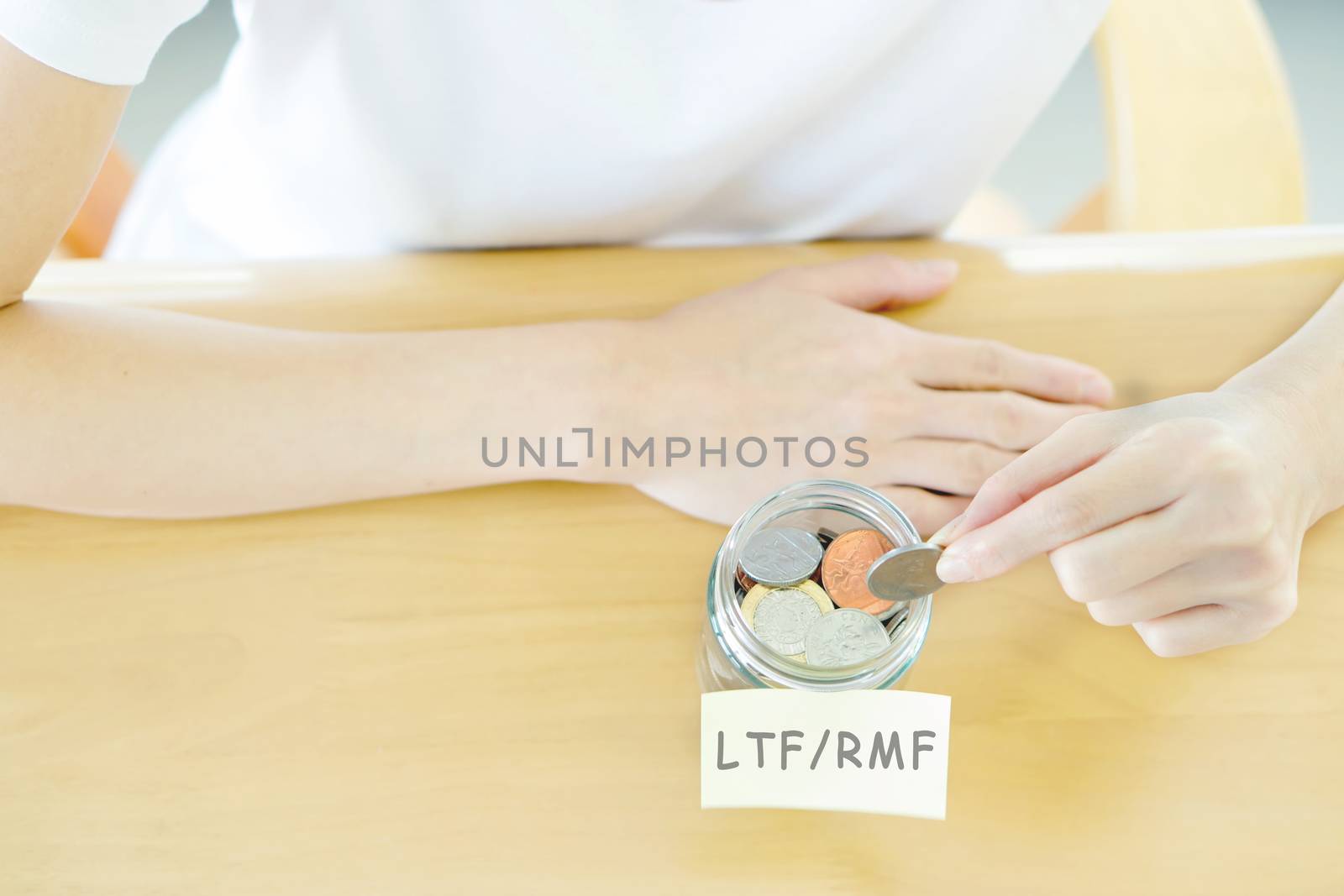 Woman hands with coins in glass jar, top view