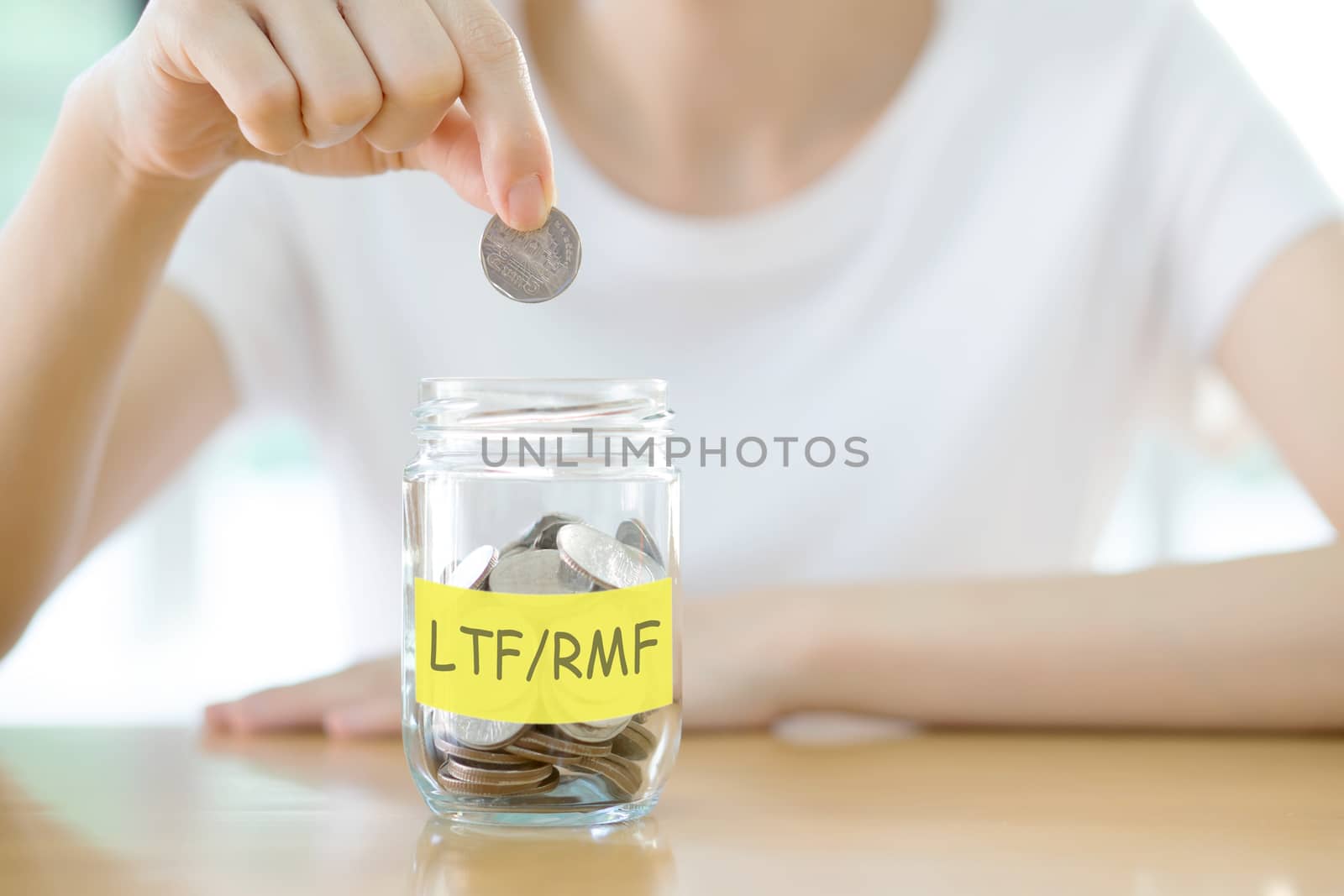 Woman hands with coins in glass jar saving money, close up by ekachailo