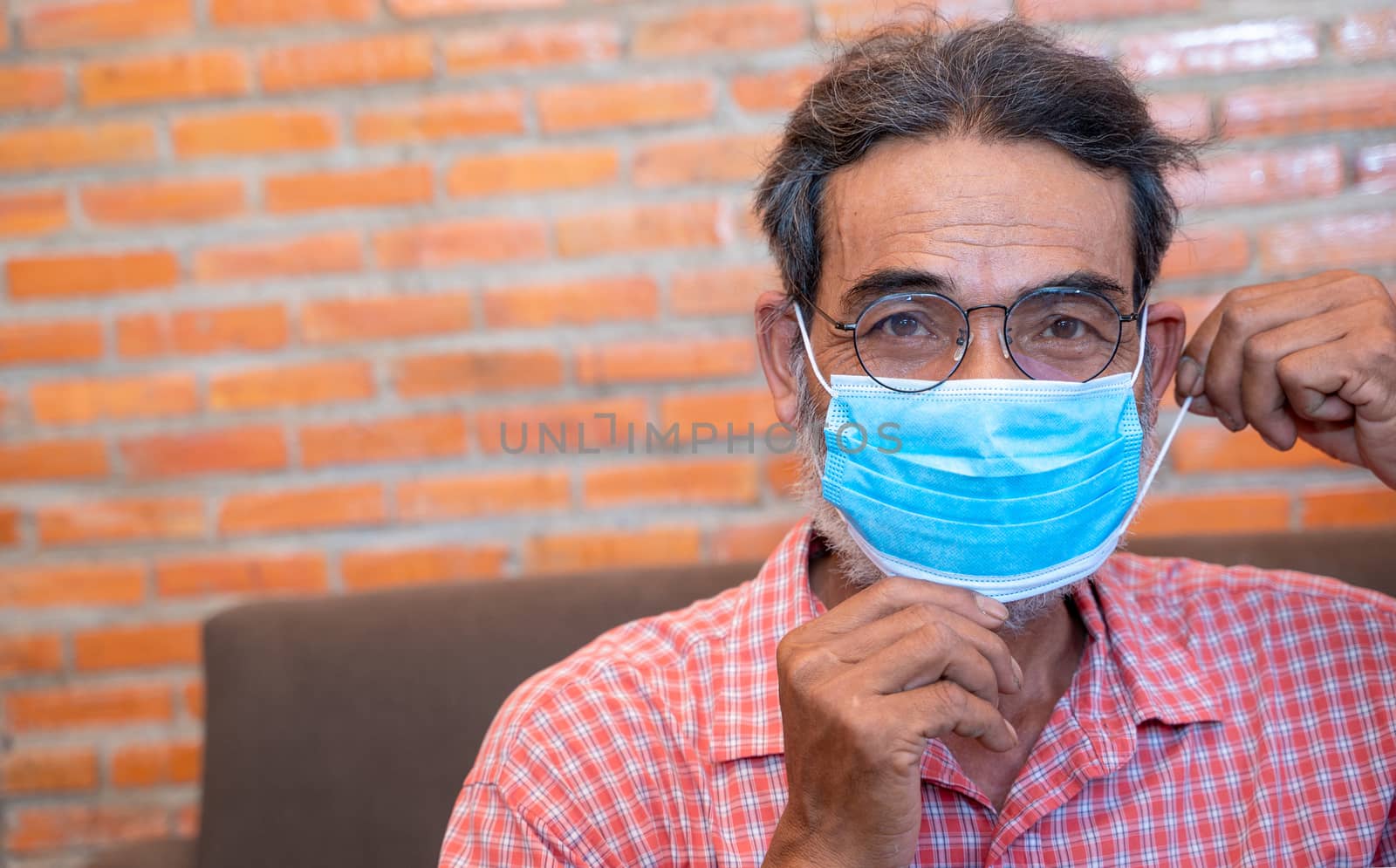 Portrait of smiling senior man ready to wearing protective mask to Protect Against Covid-19,Concept of recommendations for protection against the virus.