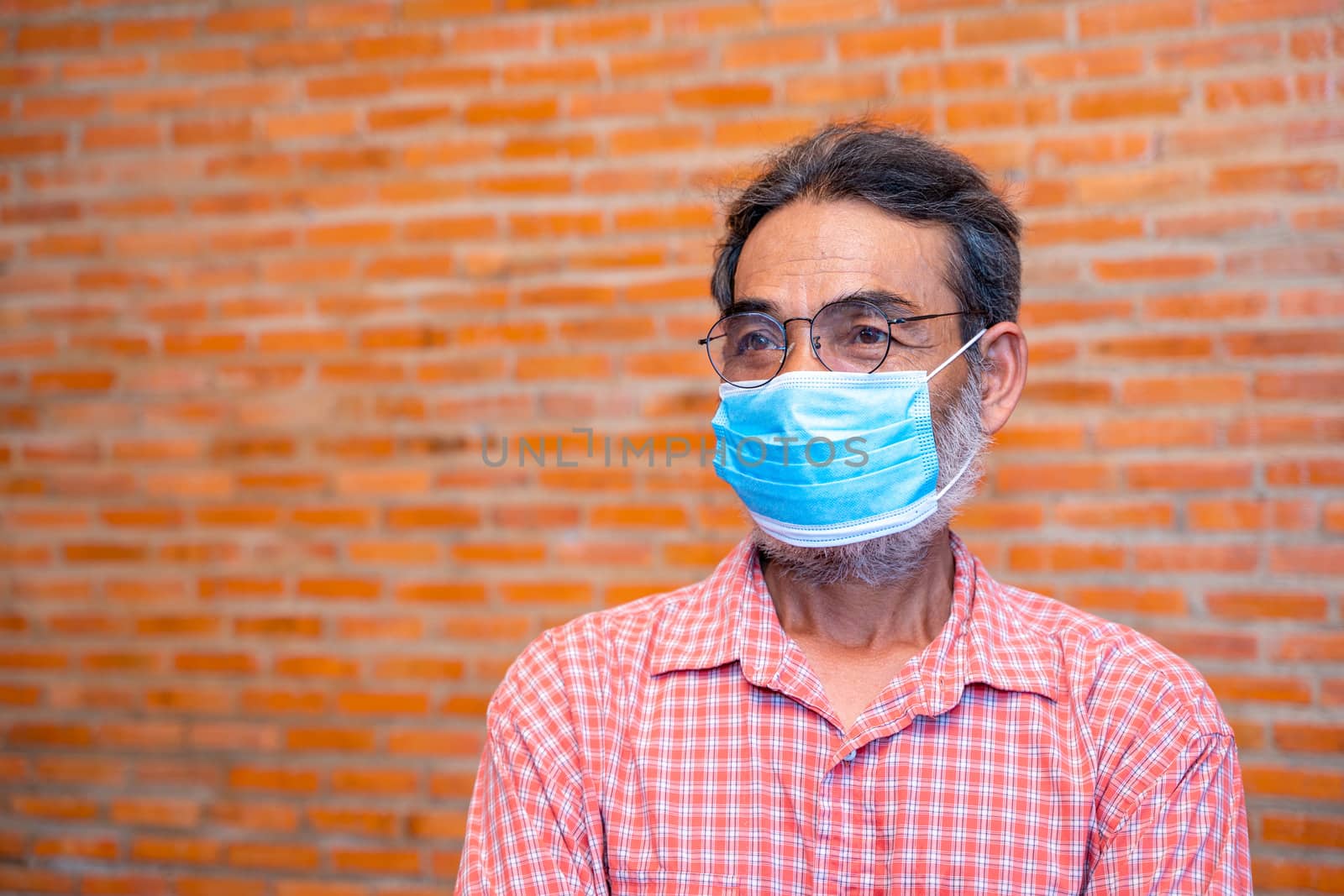 Elderly man wears protective mask against. by Visoot