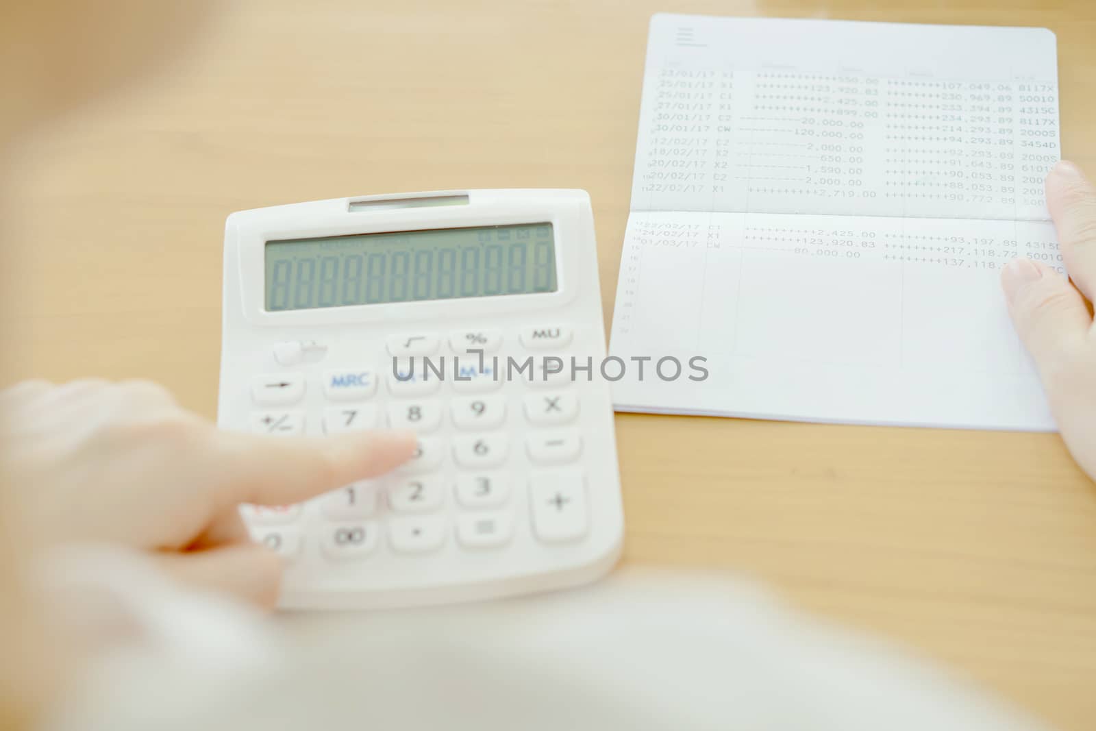 Blur businesswoman use calculator beside passbook 