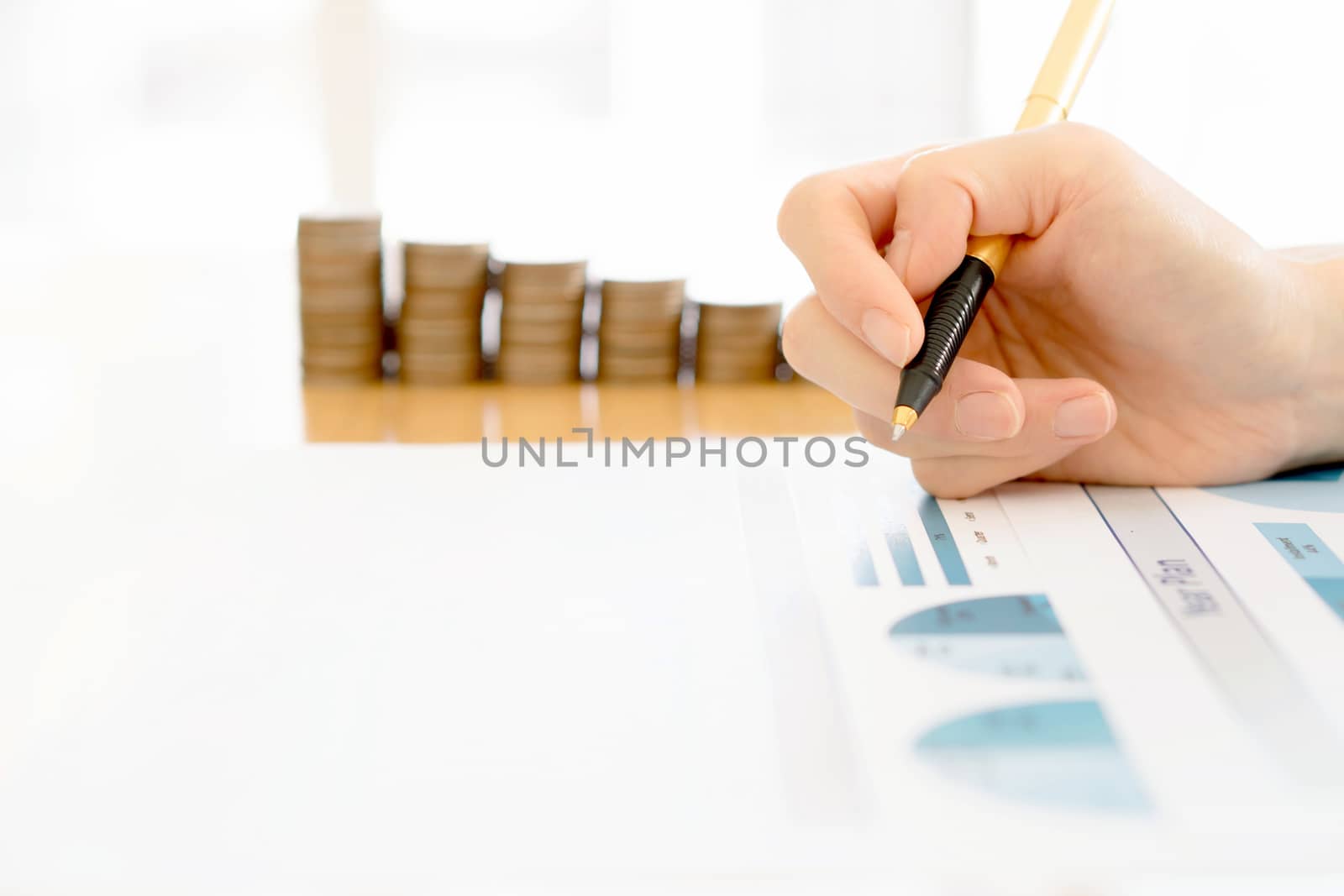 Businesswoman Analyzing Financial Graph With Coins  by ekachailo